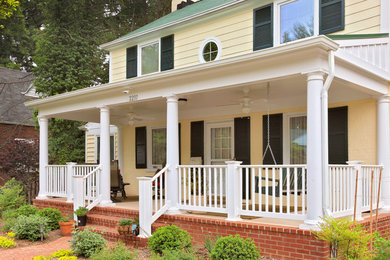 Mid-sized classic brick front porch idea in DC Metro with a roof extension