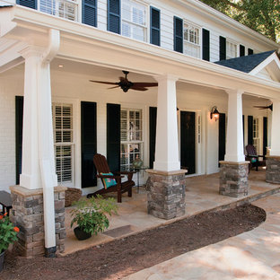 Esempio di un grande portico american style davanti casa con pavimentazioni in pietra naturale e un tetto a sbalzo