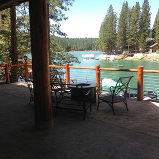 Foto di un ampio portico stile americano dietro casa con lastre di cemento e un tetto a sbalzo