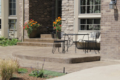 Imagen de terraza de tamaño medio en patio delantero con adoquines de hormigón