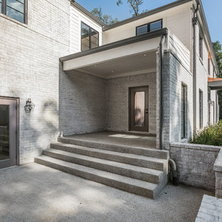 Ispirazione per un grande portico minimalista davanti casa con lastre di cemento e un tetto a sbalzo