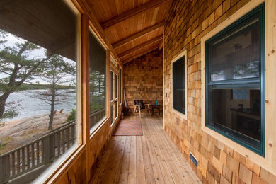 Idée de décoration pour un porche d'entrée de maison arrière chalet de taille moyenne avec une terrasse en bois et une extension de toiture.