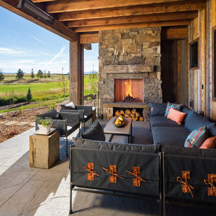 This is an example of a rustic veranda in Other with a fire feature and a roof extension.