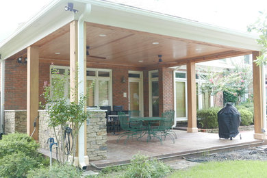 Large elegant stamped concrete porch photo in Other with a roof extension