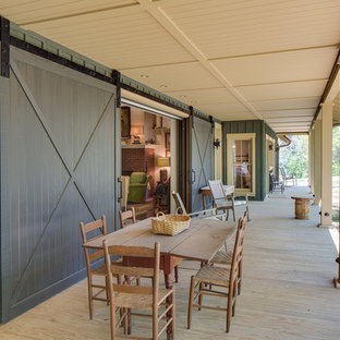 Idee per un grande portico country davanti casa con pedane e un tetto a sbalzo