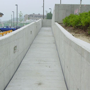 Immagine di un piccolo portico industriale nel cortile laterale con lastre di cemento