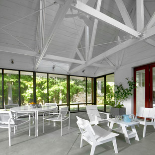 Idee per un piccolo patio o portico industriale davanti casa con un portico chiuso, lastre di cemento e un tetto a sbalzo