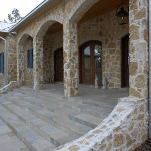 Immagine di un grande portico boho chic davanti casa con pavimentazioni in cemento e un tetto a sbalzo