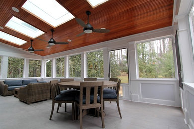 This is an example of a large transitional tile screened-in back porch design in DC Metro with a roof extension.