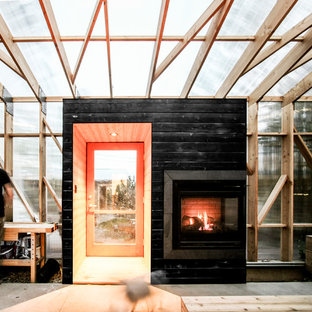 Esempio di un portico scandinavo di medie dimensioni e dietro casa con un focolare e un tetto a sbalzo