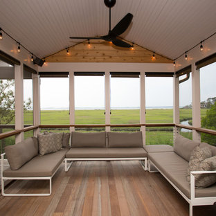 Idées déco pour un porche arrière bord de mer de taille moyenne avec une moustiquaire, une terrasse en bois et une extension de toiture.