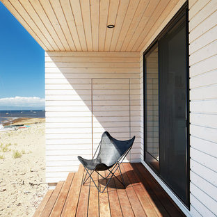 Ispirazione per un piccolo patio o portico nordico dietro casa con pedane e un tetto a sbalzo
