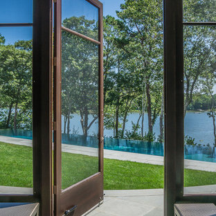 Foto di un portico minimalista di medie dimensioni e dietro casa con pavimentazioni in pietra naturale e un tetto a sbalzo