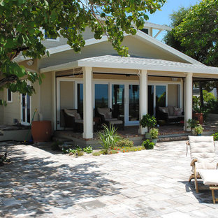 This is an example of a mid-sized traditional back porch design in Tampa with a roof extension.