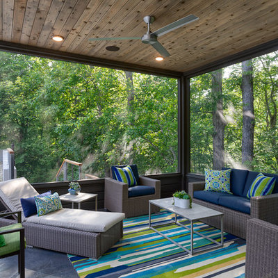 This is an example of a coastal screened-in porch design in Other with a roof extension.