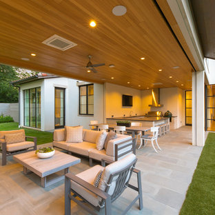 Idee per un ampio portico mediterraneo dietro casa con pavimentazioni in pietra naturale e un tetto a sbalzo