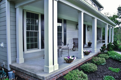 Large elegant concrete front porch photo in DC Metro with a roof extension