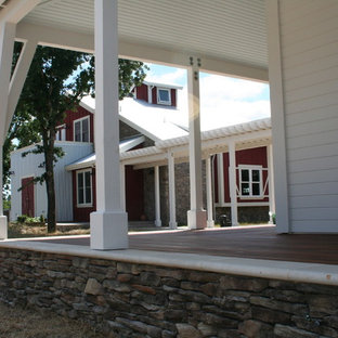 Foto di un ampio patio o portico country davanti casa con pedane e un tetto a sbalzo