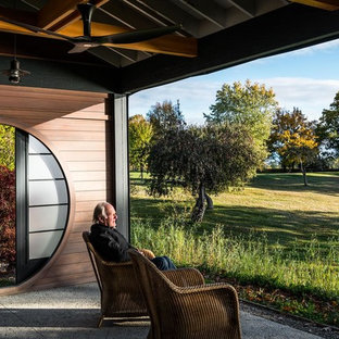 Foto di un portico etnico di medie dimensioni e dietro casa con un portico chiuso, lastre di cemento e un tetto a sbalzo