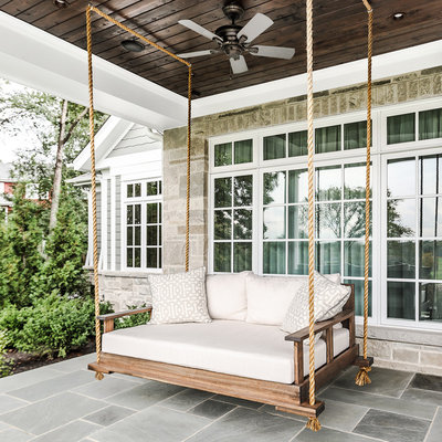 Classic stone front porch idea in Chicago with a roof extension