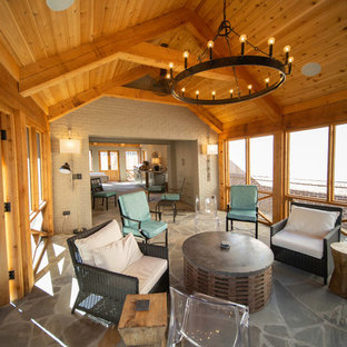 Idee per un grande portico stile americano dietro casa con un caminetto, pavimentazioni in pietra naturale e un tetto a sbalzo