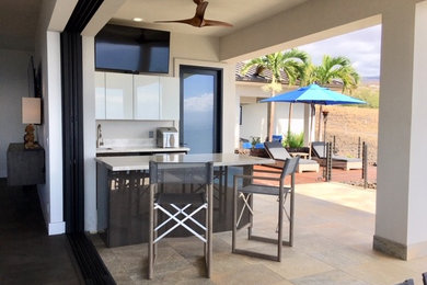 Cette image montre un porche d'entrée de maison arrière minimaliste de taille moyenne avec une cuisine d'été, du béton estampé et une extension de toiture.