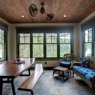 Foto di un portico stile americano di medie dimensioni e dietro casa con un portico chiuso, un tetto a sbalzo e pavimentazioni in pietra naturale