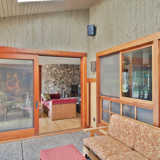 Foto di un grande portico tropicale dietro casa con un tetto a sbalzo, un portico chiuso e lastre di cemento