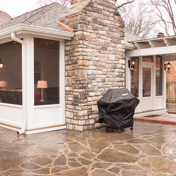 Light and airy screened porch with stone veneered fireplace