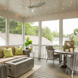Immagine di un patio o portico chic con un portico chiuso, pedane e un tetto a sbalzo
