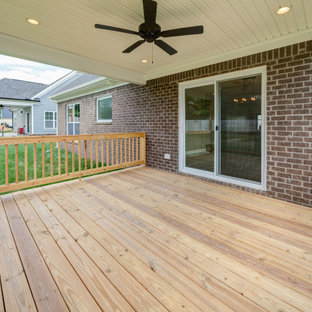 Idee per un portico american style dietro casa con pedane, un tetto a sbalzo e parapetto in legno