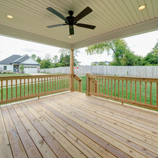 Immagine di un portico american style dietro casa con pedane, un tetto a sbalzo e parapetto in legno