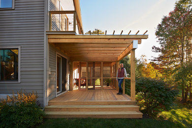 Mid-sized minimalist screened-in side porch idea in Burlington with a pergola