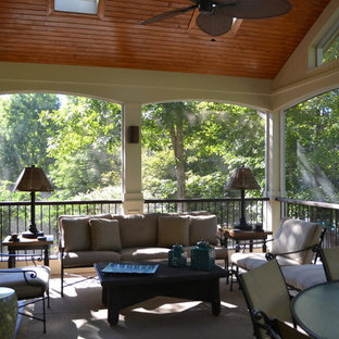 Immagine di un grande patio o portico chic dietro casa con un portico chiuso, piastrelle e un tetto a sbalzo