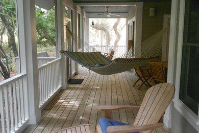 Klassisk inredning av en mellanstor innätad veranda på baksidan av huset, med trädäck och takförlängning