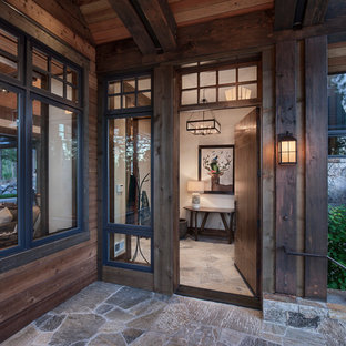 Idee per un grande portico davanti casa con pavimentazioni in pietra naturale e un tetto a sbalzo