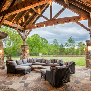 Idee per un grande portico stile rurale dietro casa con un caminetto