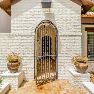 Esempio di un grande portico mediterraneo davanti casa con fontane, pavimentazioni in mattoni e un parasole