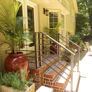 Ispirazione per un piccolo portico tradizionale dietro casa con un giardino in vaso, pavimentazioni in mattoni e un tetto a sbalzo