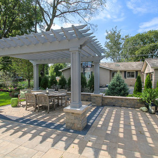 Immagine di un grande portico country dietro casa con pavimentazioni in mattoni e una pergola