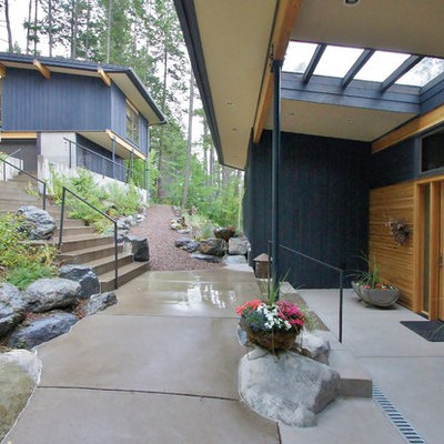 This is an example of a contemporary concrete porch design in Seattle with a roof extension.