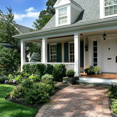 This is an example of a traditional front porch design in New York with decking and a roof extension.