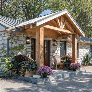Immagine di un grande patio o portico country davanti casa con un giardino in vaso, lastre di cemento e un tetto a sbalzo