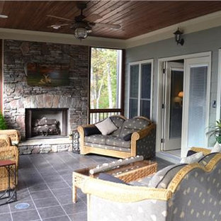 Esempio di un grande portico stile americano dietro casa con un portico chiuso, piastrelle e un tetto a sbalzo