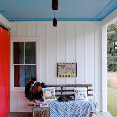 This is an example of a country porch design in New York with decking and a roof extension.