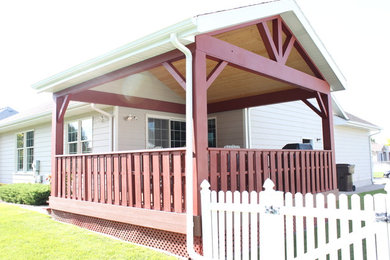 Idée de décoration pour un porche d'entrée de maison latéral chalet de taille moyenne avec une extension de toiture.