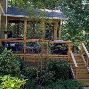 Idee per un grande portico stile rurale dietro casa con un portico chiuso e parapetto in metallo