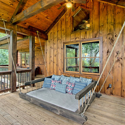 This is an example of a mid-sized rustic front porch design in Other with a roof extension.
