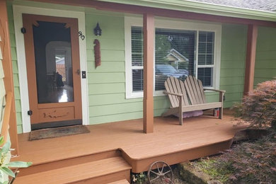 Mid-sized mountain style front porch idea in Seattle with decking and a roof extension