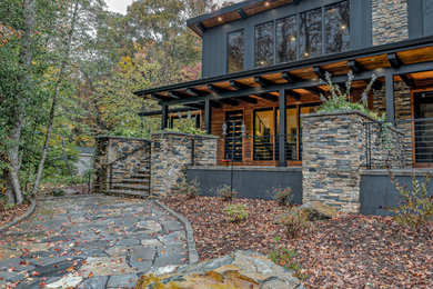 Mid-sized mountain style stone front porch photo in Raleigh with a roof extension